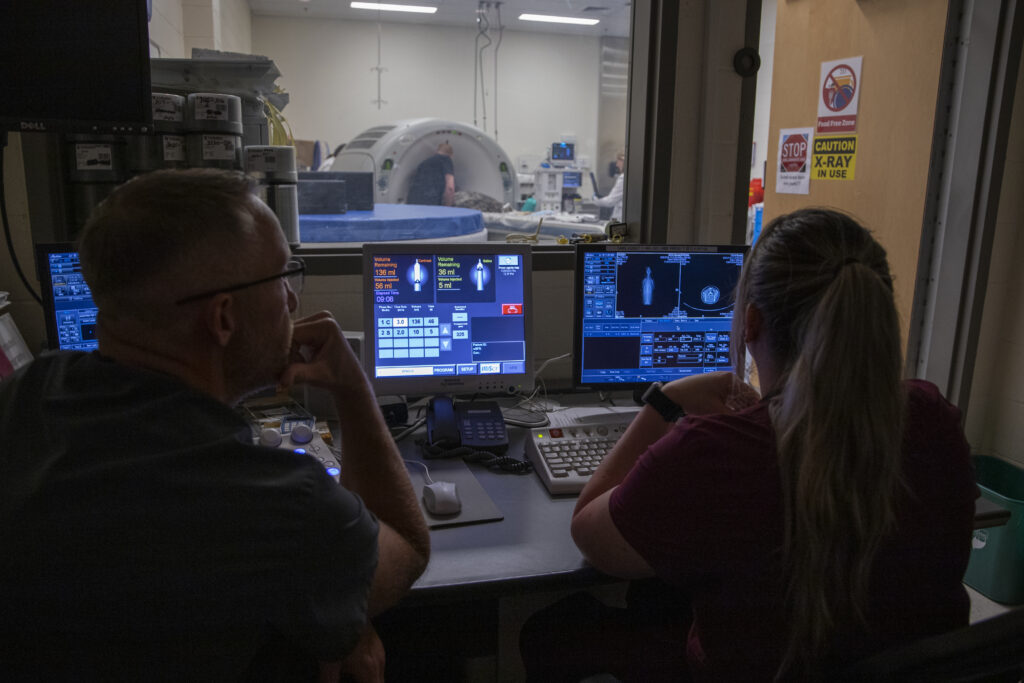 Vet staff view monitors during the scan.