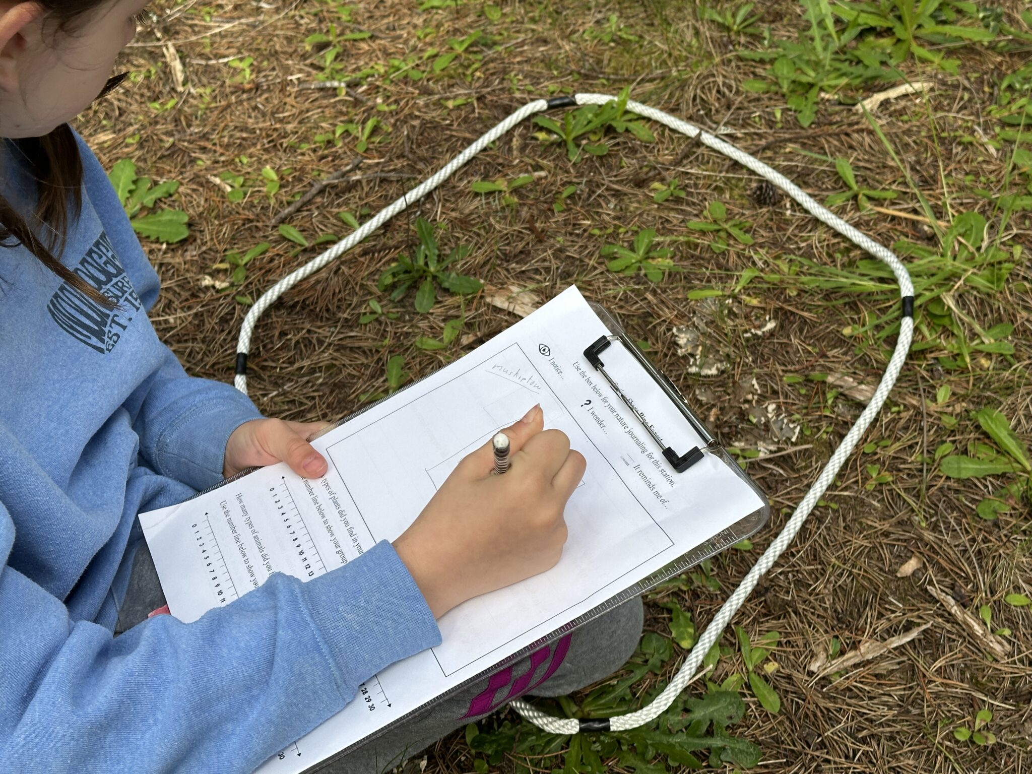 Close up on a student working on a clipboard